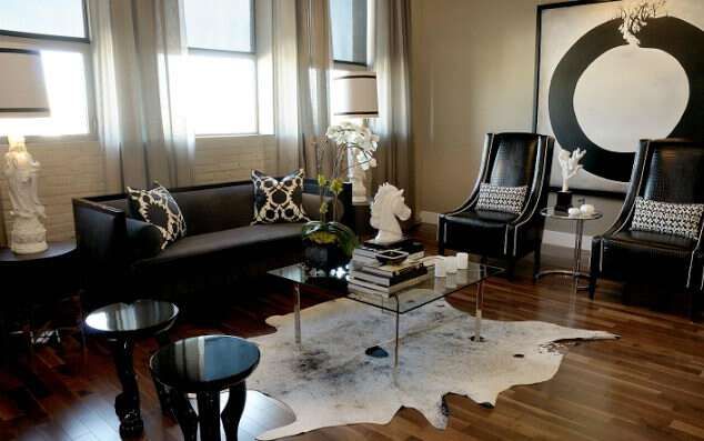 Чёрная мебель диван и кресла в светлой комнате с деревянным полом