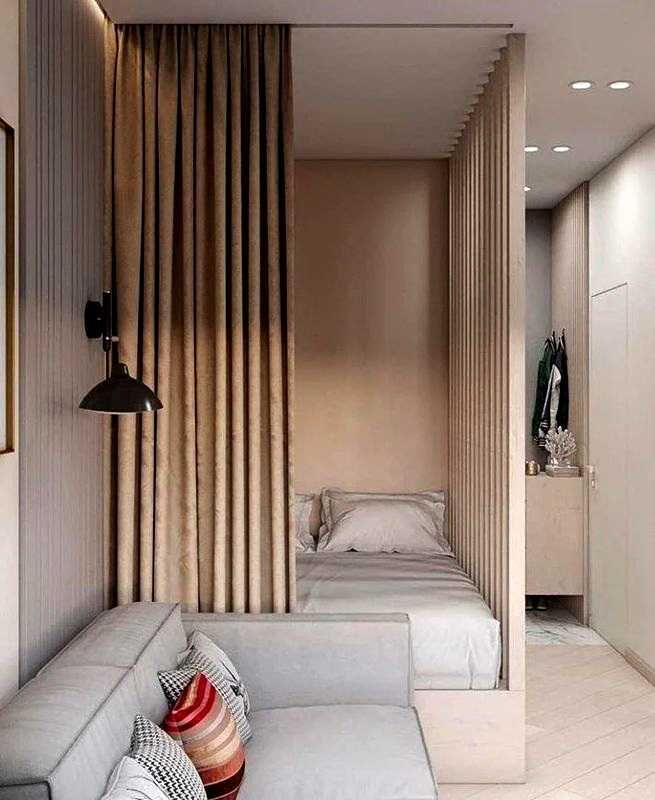 спальня рядом с диваном в студии отделена шторой и реечной перегородкой