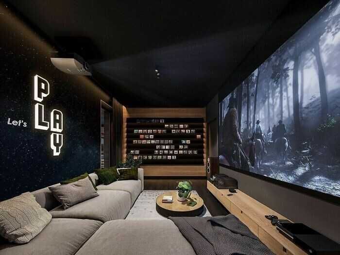 домашний кинотеатр с чёрным потолком и тёмно-синими стенами, серый диван
