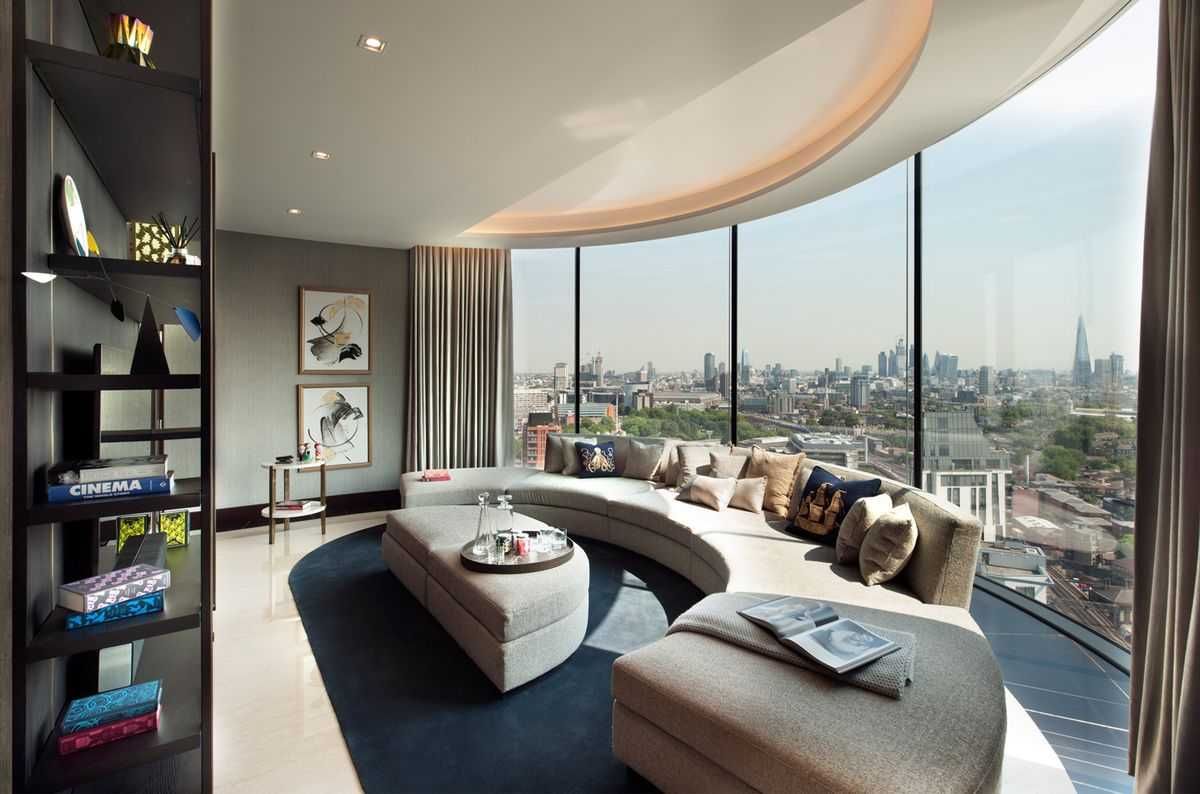 современная гостиная с панорамным полукруглым окном, диван в центре комнаты