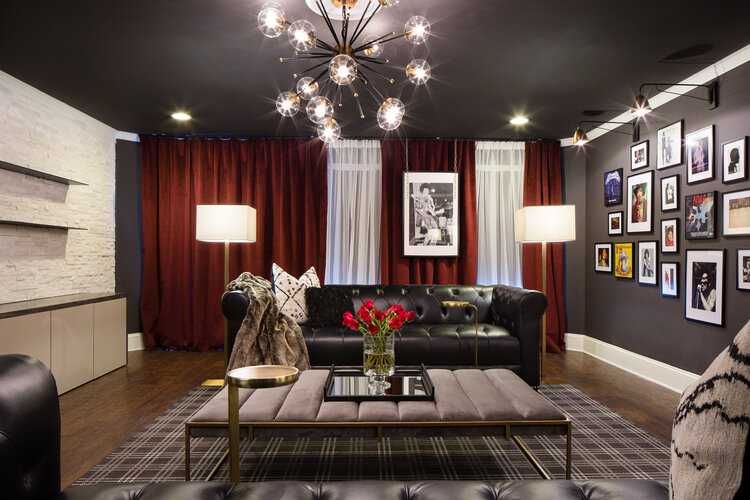 гостиная с ярким освещением, чёрным потолком и стенами, бордовые шторы