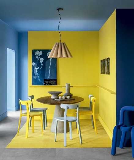 Яркая жёлтая зона кухни в углу комнаты на фоне синего, зонирование цветом