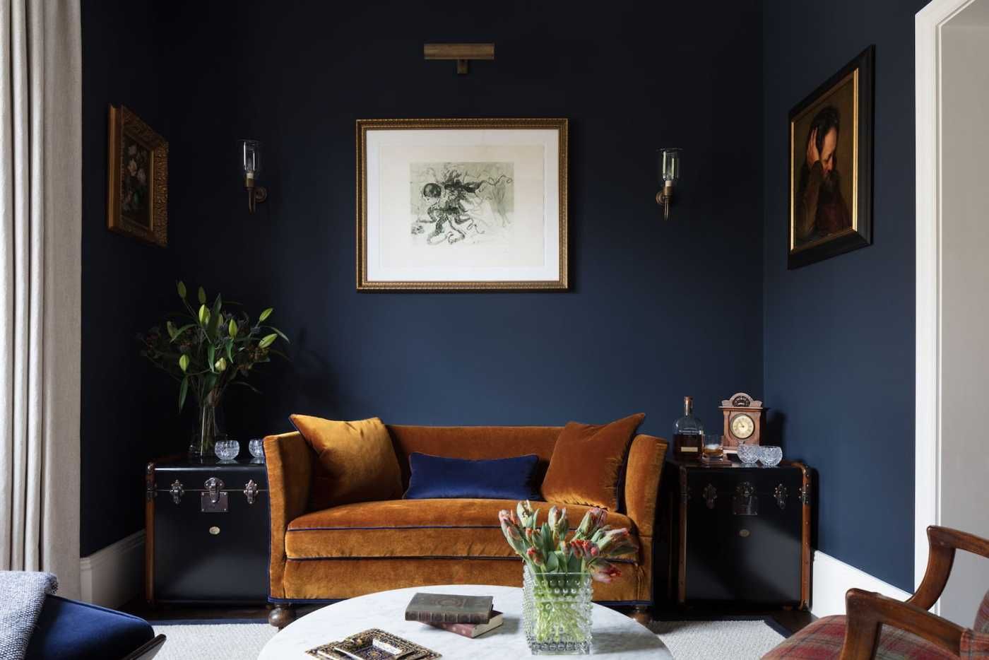 маленькая гостиная с тёмно-синими стенами и жёлтым диваном