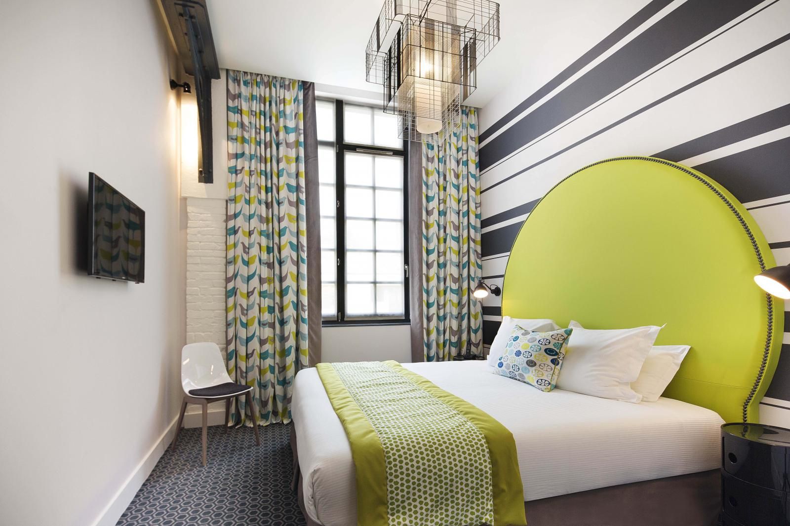 дизайн спальни с ярким салатовым изголовьем, горизонтальные полоски за кроватью